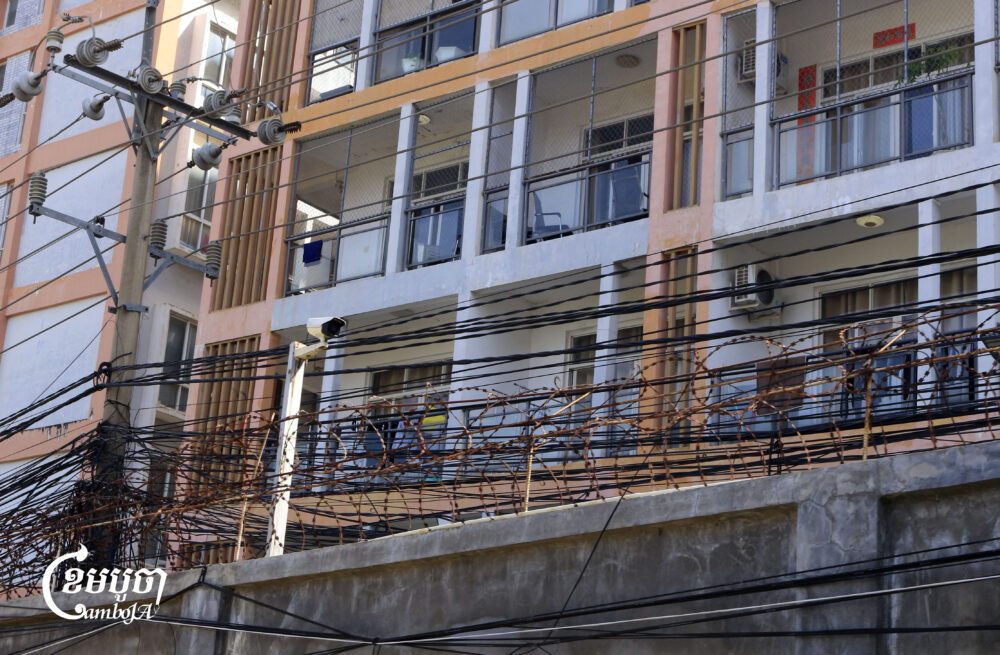 Razor-wire and surveillance mark the perimeter of a suspected scam compound in Bavet City. (CamboJA/Coby Hobbs)