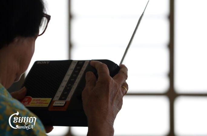 An elderly woman listens to the radio at her house in Phnom Penh. August 10, 2025. (CamboJA/Pring Samrang)