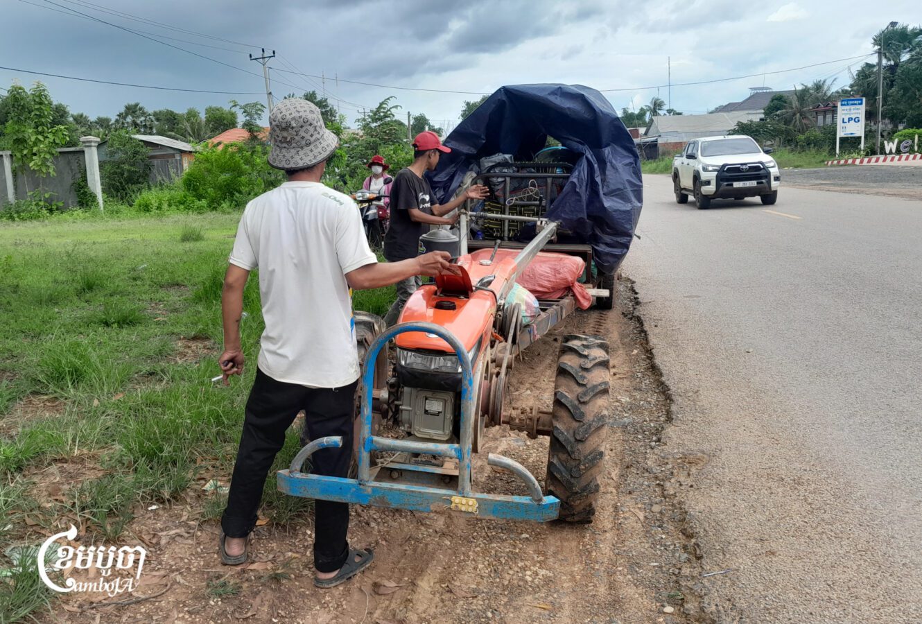 A man pours fuel into his tractor on the way to a safety center in Preah Vihear province. Sept. 25, 2025. (CamboJA/Va Sopheanut)