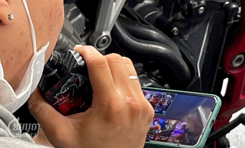 A youth smokes an e-cigarette at a coffee shop in Phnom Penh, December 23, 2022. (CamboJA/Pring Samrang)