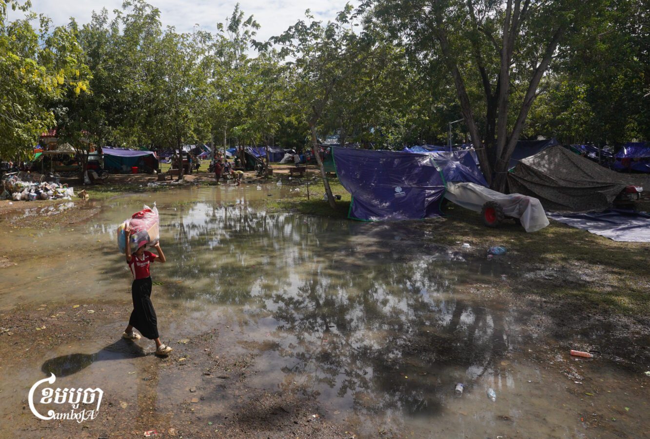 A girl carries donated items on her head to her tent in a pagoda in O’Chrov district, Banteay Meanchey province on November 18, 2025. (CamboJA/ Yarn Soveit)