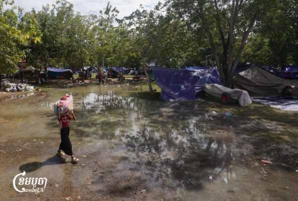 A girl carries donated items on her head to her tent in a pagoda in O’Chrov district, Banteay Meanchey province on November 18, 2025. (CamboJA/ Yarn Soveit)