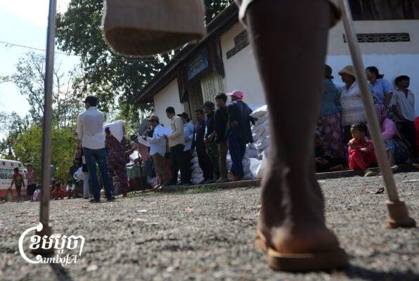A man with disability along with other displaced people receive milled rice from humanitarian workers at a relief camp in Preah Vihear province as clashes between Cambodia and Thai entered its fifth day. Photo taken on December 12, 2025. (Cambodia/ Yousos Apdoulrashim)